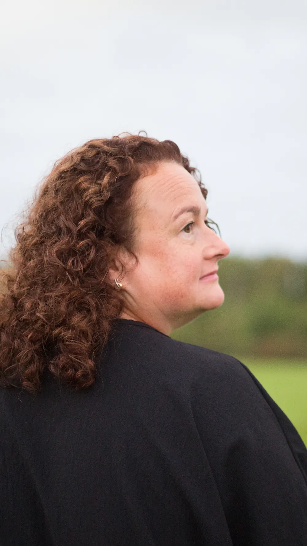 Christiane Wenzel im Profil, sie blickt über ein weites Feld.